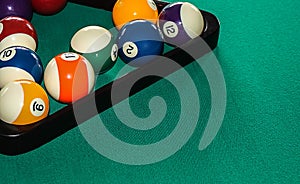 Billiard balls in a triangular rack in the corner of the table with space for text.