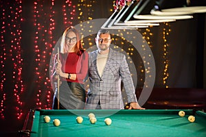 Billiard club. A nice pretty married couple standing by the table
