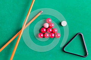 Billiard colorful balls with wooden cue on green table. Snooker, Pool game. Top view.