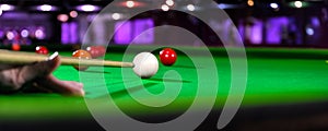 Billiard cue of professional snooker player closeup aiming shot white ball