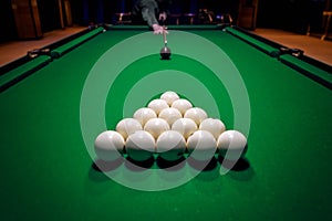 Billiard man player arm breaking the pyramid by striking the ball with cue stick