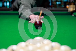 Billiard man player arm breaking the pyramid by striking the ball with cue stick