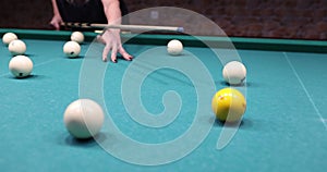 Billiard player is ready to hit yellow ball on blue billiard table in club
