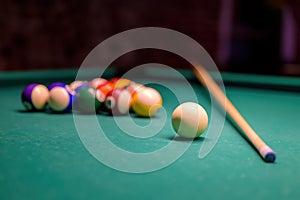 Billiard pool game, colored balls with cue stick and cue ball set on billiard table with green cloth