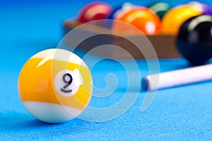 Billiard pool game nine ball with cue on billiard table