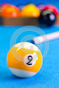 Billiard pool game nine ball with cue on billiard table