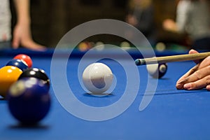 Billiard pool game player aims to shoot balls with cue