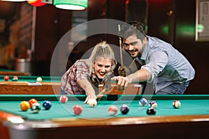 Billiard- smiling couple shooting pool ball