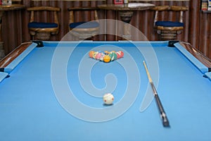 Billiard table with cue and balls ready for playing