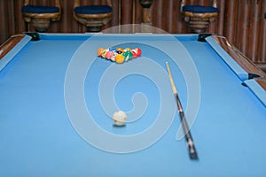 Billiard table with cue and balls ready for playing