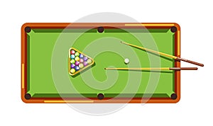 Billiard table with green field, wooden cues and colorful balls