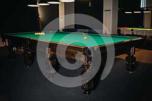 Billiard table with green surface and balls in the billiard club