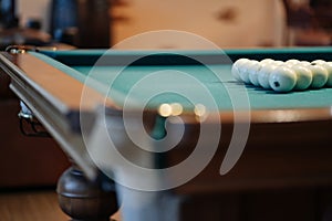 Billiard table with green surface and balls in the billiard club.