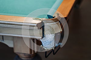 Billiard table with green surface and balls in the billiard club.