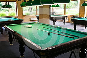 Billiard tables in the room without people, with lighting