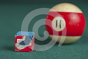 Billiards balls and cue on billiards table. Billiard sport concept. Chalk block on biliard table