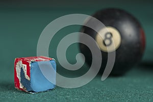 Billiards balls and cue on billiards table. Billiard sport concept. Chalk block on biliard table