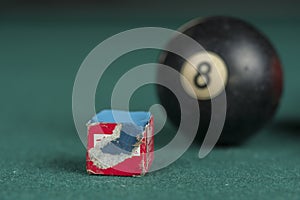 Billiards balls and cue on billiards table. Billiard sport concept. Chalk block on biliard table