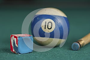 Billiards balls and cue on billiards table. Billiard sport concept. Chalk block on biliard table