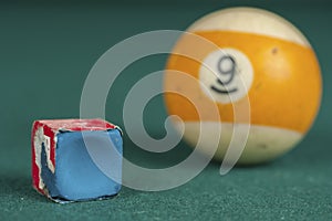 Billiards balls and cue on billiards table. Billiard sport concept. Chalk block on biliard table