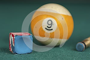 Billiards balls and cue on billiards table. Billiard sport concept. Chalk block on biliard table