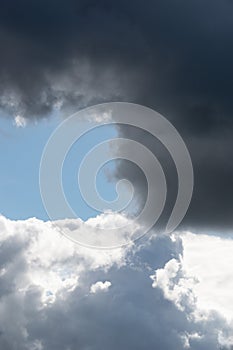 Billowing grey white clouds with blue sky. Stormy weather.