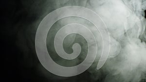 Billowing smoke on black background. Stock footage. Muddy defocusing clouds of white smoke spreading out on black