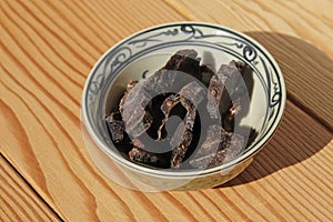 Biltong (dried meat) on a wooden board, this is a traditional food snack