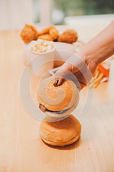 Binge eating disorder concept with woman eating fast food burger, fired chicken , donuts and desserts photo