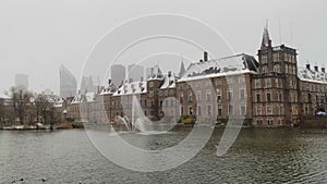 Binnenhof Palace in The Hague or Den Haag and Hohvijfer canal during winter snow in The Netherlands