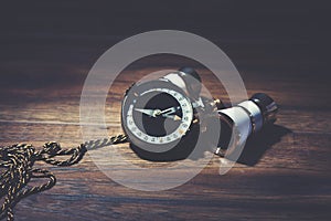 Binocle with compass on wooden background