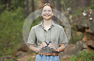 Binocular, forest and portrait of happy woman hiking for nature journey, jungle adventure and travel in outdoor explore