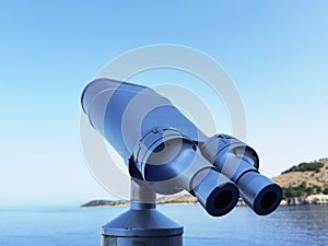 Binocular isolated on the blue sky watching on the sea