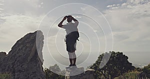 Binocular, rock or man looking at mountain climbing view of morning journey, travel exploration or outdoor hiking