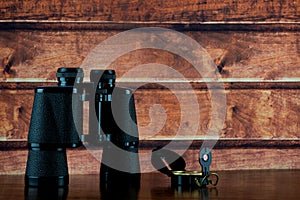 Binoculars and Compass on a Varnished Wooden Shelf