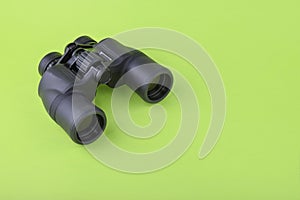 Binoculars on green background
