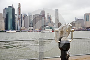 Binoculars looking to the Manhattan skyline over East River in rainy day