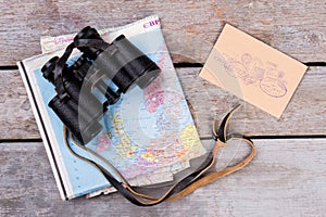 Binoculars upon map and post mail with stamps.