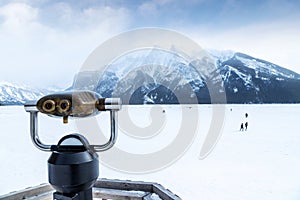 Binoculars overlooking Lake Minnewanka and cloud-covered Mount Inglismaldie in Banff
