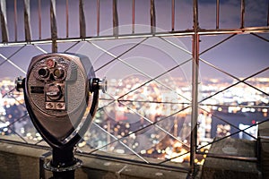 Binoculars on top of Empire State Building at Night in Manhattan