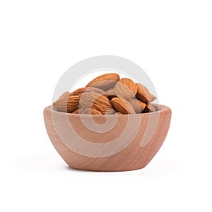 Bio organic almonds in wooden bowl isolated on white background.