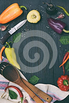 Bio organic fresh summer vegetables - different varieties of sweet and hot peppers on dark wooden background. Ingredients for cook
