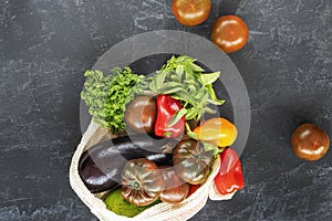 Bio organic vegetables on black chalkboard background, healthy raw vegan food concept. Top view, flat lay