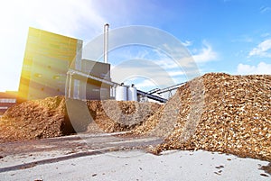 Bio power plant with storage of wooden fuel against blue sky