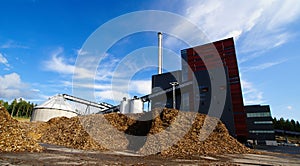 bio power plant and storage of wooden fuel against blue sky