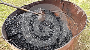 biochar in a can with a shovel. charcoal for use as fertilizer in the vegetable garden