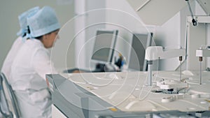 Biochemical analyzing machine at work in a laboratory with several workers