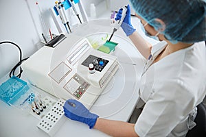 Biochemist using a pipettor for transferring milliliter volumes of liquid