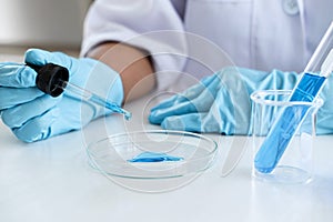 Biochemistry laboratory research, Scientist or medical in lab coat holding test tube with using reagent with drop of color liquid