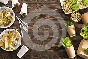 Biodegradable and plastic tableware on wooden background. Secondary processing. The concept of zero waste.